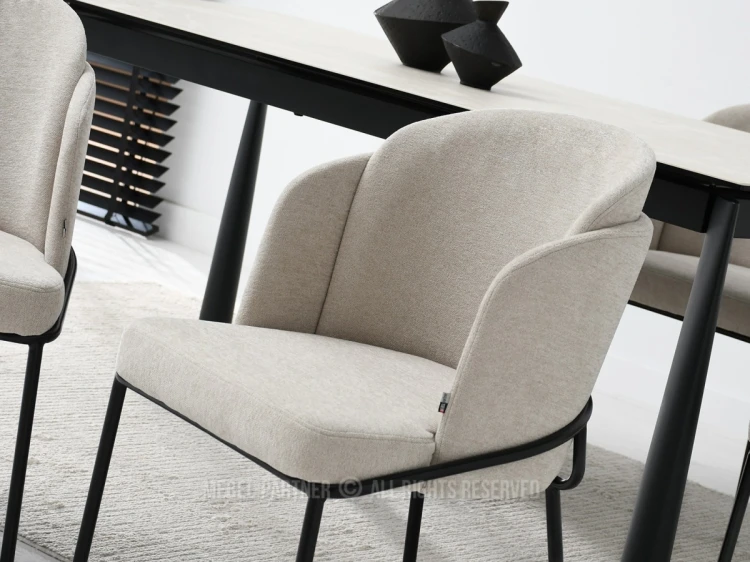 Modern beige gepolsterter Esszimmerstuhl mit schwarzen Metallbeinen, Nahaufnahme.
