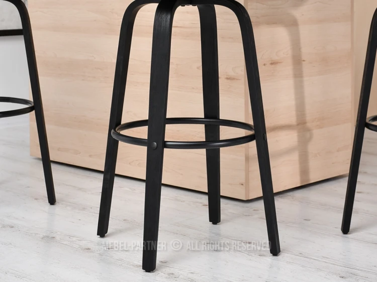 Stabile Holzbeine und runder Fußring eines schwarzen Barhockers im Detail.