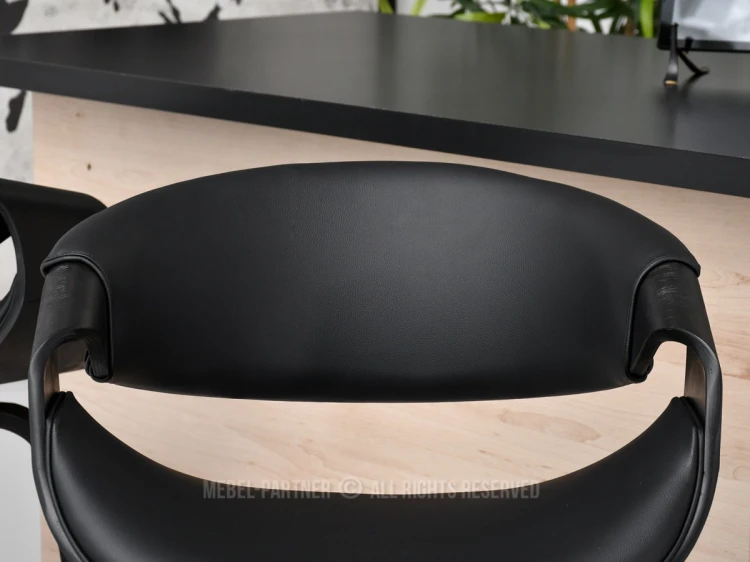 Bequeme Sitzfläche und ergonomische Rückenlehne eines schwarzen Barhockers.