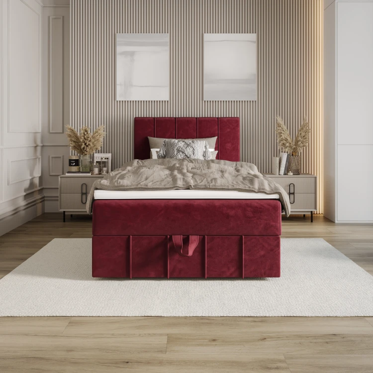 Burgunderrotes Boxspringbett in einem modern eingerichteten Zimmer.