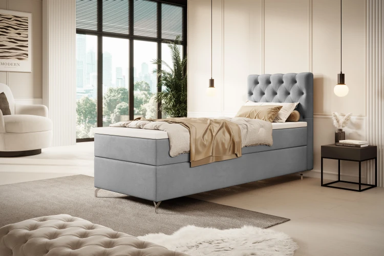 Einzelbett Boxspring in Grau mit gemütlicher Bettwäsche im Loft-Stil.