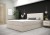 Helles Boxspringbett in Beige vor einer dekorativen schwarzen Wandpaneele.